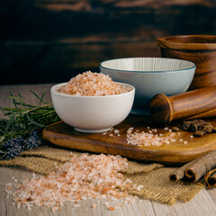 Pink Himalayan Salt on wooden table background. Herbs, spices and dried food baking ingredient. Mortar and different spices. Cottage kitchen. Product Photography