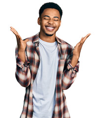 Young african american man wearing casual clothes celebrating mad and crazy for success with arms...