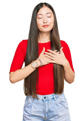 Young chinese woman wearing casual clothes smiling with hands on chest with closed eyes and grateful gesture on face. health concept.