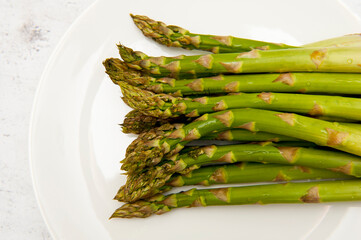 Top view of green asparagus on white plate - 774958216