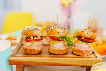 Mini burgers as an appetizer on the festive table. A treat for a children's birthday party. Catering.