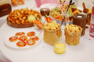 French fries in buckets on the table. Original serving of potatoes.