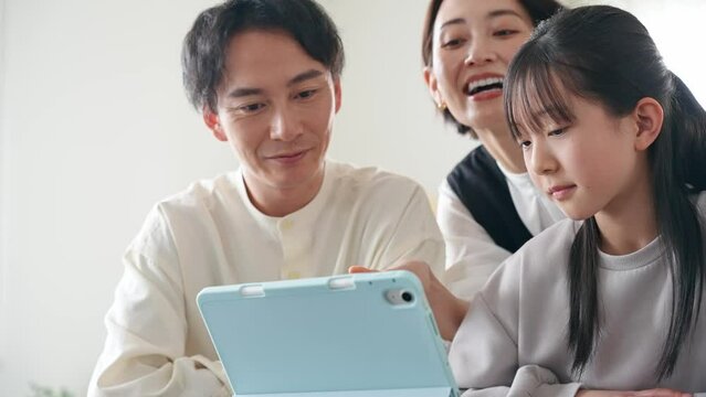みんなでタブレットを見る家族