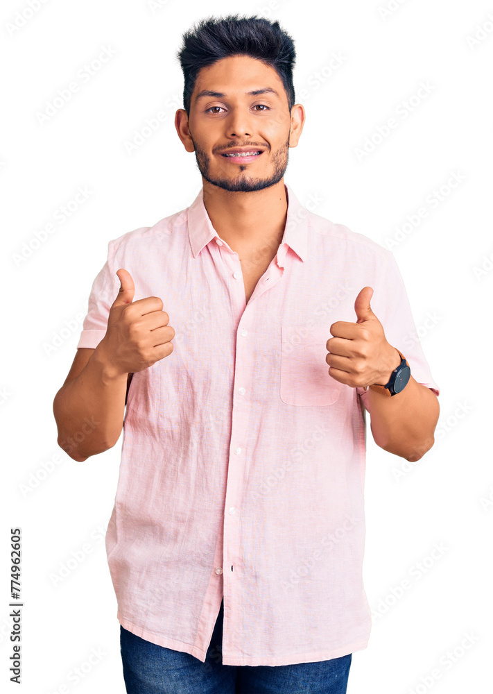 Wall mural handsome latin american young man wearing casual summer shirt success sign doing positive gesture wi