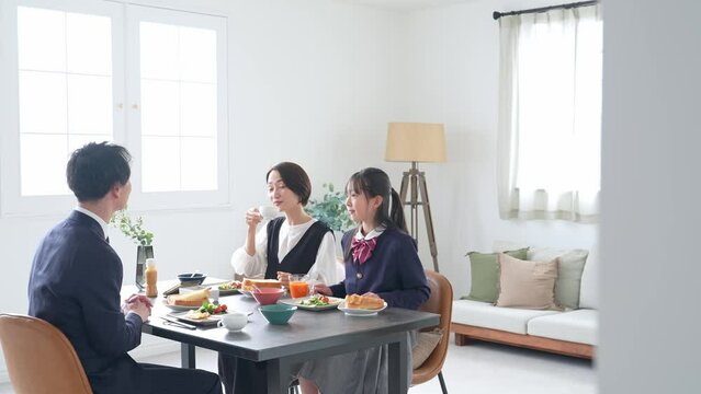 シンプルな部屋で食事する家族