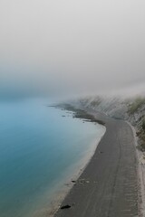 Vertical shot of sea water covering an empty sandy beach