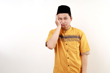 Young asian man wearing typical muslim clothes isolated on white background who is bored, fatigued...