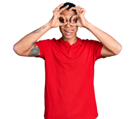 Young hispanic man wearing casual red t shirt doing ok gesture like binoculars sticking tongue out, eyes looking through fingers. crazy expression.
