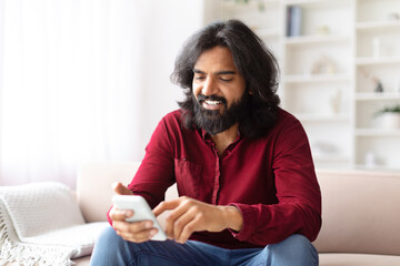 Engrossed man using phone with a smile