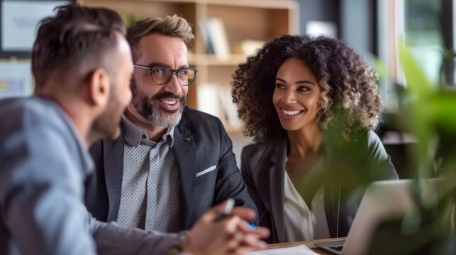 Inclusive productivity: A man and two women sit at a table, leveraging their diverse perspectives for effective collaboration