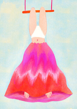 Young girl or woman hanging upside down on an acrobats swing with a colorful skirt over her head, upside down girl