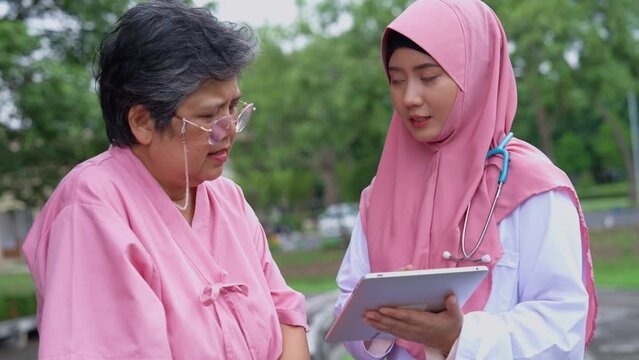 Muslim careful caregivers or doctors hold the tablet to Explain guidelines and treating disease, physical therapy.  Concept of happy retirement with care from a caregiver and senior health insurance.