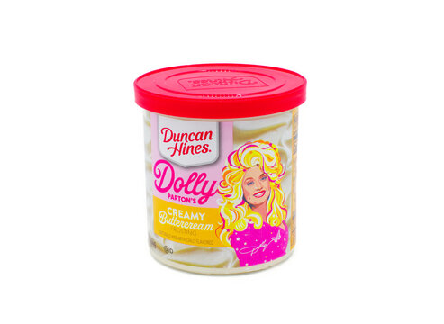 Ocala, FL 3-31-2024 Dolly Parton creamy buttercream frosting by Duncan Hines, naturally and artificially flavored. pink and yellow colors on container with bright red top isolated on white background