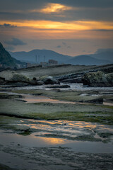 Sunset time at the coastline of Badouzi, sunlight shines on the water with gorgeous rocks and...