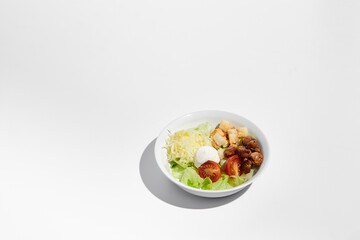 Classic Caesar salad prepared and served in a white bowl