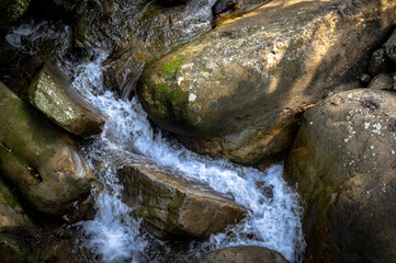 River go through gorgeous rock in the creek, sunlight shines on the rocks, in Nuandong Valley,...
