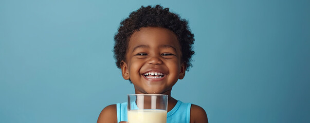 Happy African American little boy with glass of milk isolated on blue background