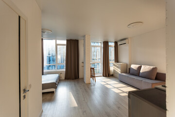 Modern room, home office interior. Room with sofa, desk, chair, small table and other furniture.