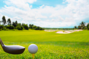 Grass field with golf balls placed on a yellow tee.