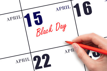 April 15. Hand writing text Black Day on calendar date. Save the date.
