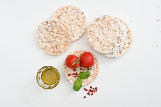 Gallette di riso o rice crackers on white background isolated whit tomatoes extra virgin oil and salt