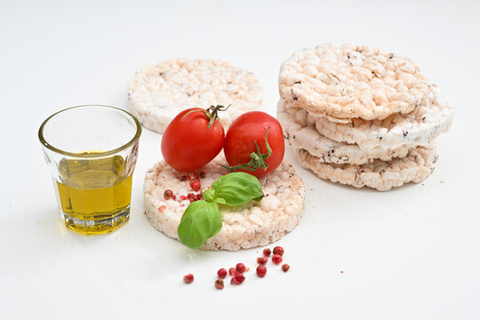 Gallette di riso o rice crackers on white background isolated whit tomatoes extra virgin oil and salt