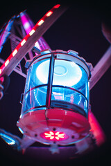 Vertical low angle shot of a modern attraction in the amusement park at night