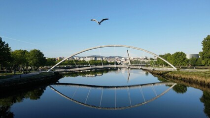 Pedestrian bridge over the river Lerez symmetrically reflects on the water