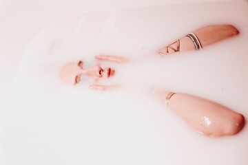 Beautiful shot of a woman lying in the bathtub with white soupy water
