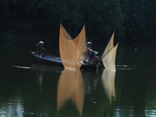 Pulling nets to catch fish on Nhu Y River, Hue. Photo taken in Hue in September 2022

 - obrazy, fototapety, plakaty