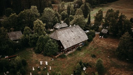 Aerial view of a farmhouse surrounded by pine trees