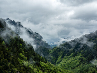 Stormy skies over a steep forested valley (Kurobe Dam in the Japanese Northern Alps)