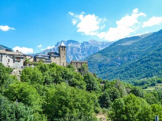 Fototapeta na wymiar Beautiful shot of an old castle over mountain surrounded by greenery under blue sky