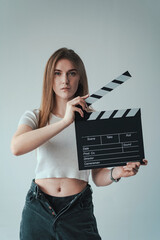 girl with a clapperboard in her hands on a light background. mock up