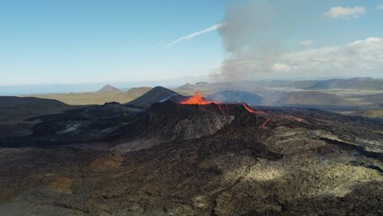 Landscape of erupting Mauna Loa Volcano in Hawaii with smoke and blue sky horizon