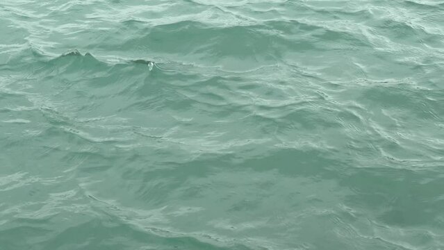 The water is beautiful turquoise color with fine waves and vibrations. Close up