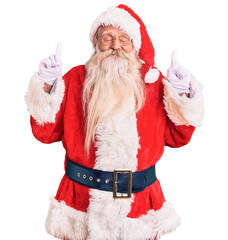 Old senior man with grey hair and long beard wearing traditional santa claus costume gesturing finger crossed smiling with hope and eyes closed. luck and superstitious concept.