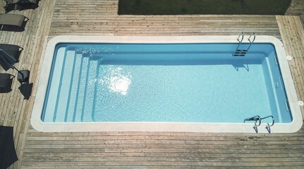 Aerial view of the bright sunlight reflected in swimming pool with wooden deck