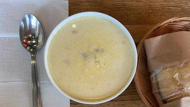 close-up cheese soup in a bowl with croutons, girl stirs soup with a spoon. 