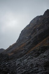 Rocky cliff on a coast by a river with misty sky on the horizon in Murmansk