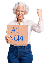 Senior grey-haired woman holding act now banner screaming proud, celebrating victory and success...
