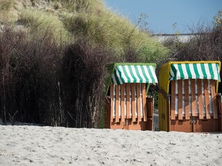 Green-white striped roofed wooden buildings on the beach in Germany.