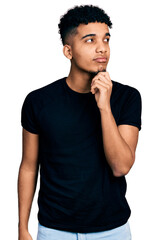 Young african american man wearing casual black t shirt thinking concentrated about doubt with...