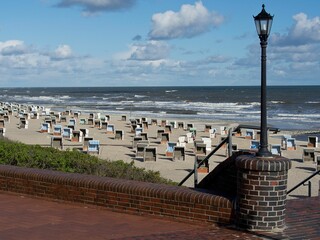 Image of a sandy beach with numerous chairs in front of the North Sea in Wangerooge, Germany
