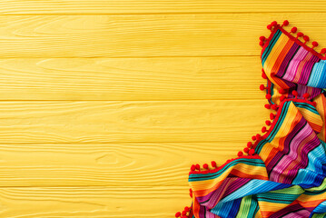 Celebrate Cinco de Mayo with this festive top view display: traditional striped serape on yellow...