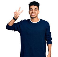Young african american man wearing casual clothes smiling looking to the camera showing fingers...
