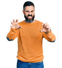 Hispanic man with beard wearing casual winter sweater smiling funny doing claw gesture as cat,...