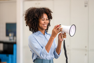 African american woman wearing blue shirt shouting loud holding a megaphone, expressing success and...