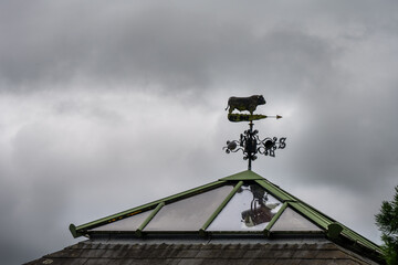 Weather vane representing a bull against a cloudy sky