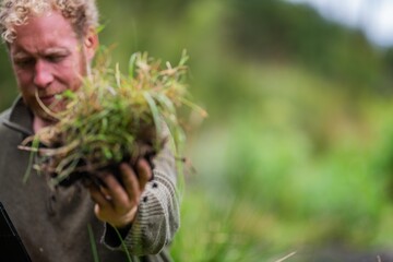 regenerative organic farmer, taking soil samples and looking at plant growth in a farm. practicing sustainable agriculture in a field